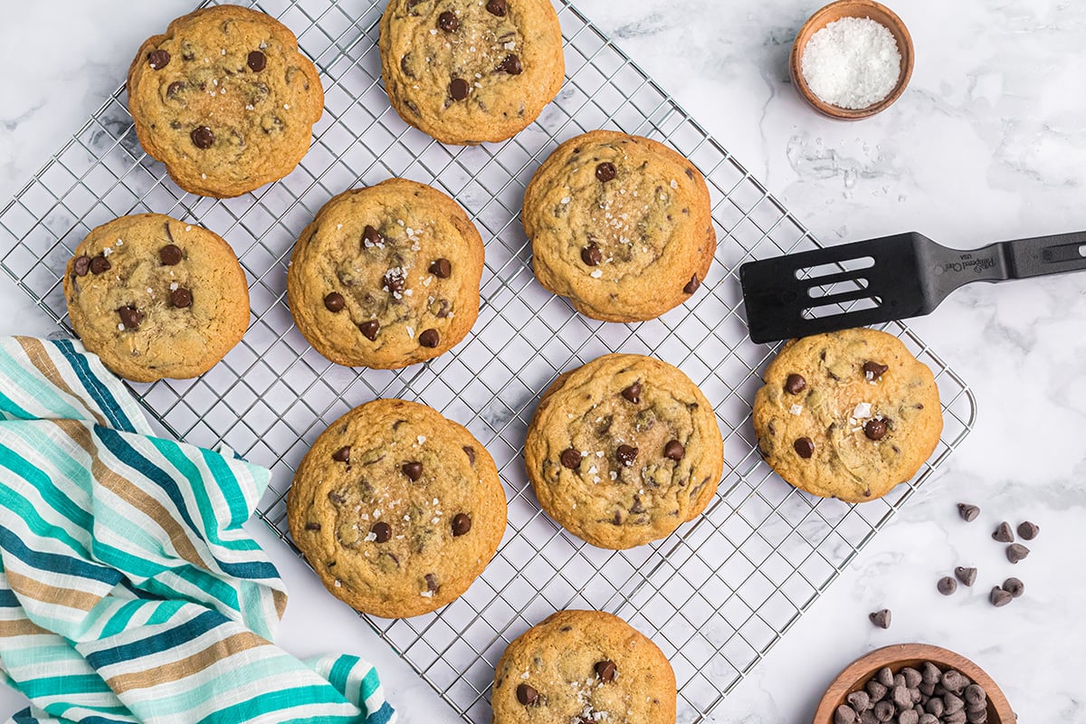 browned cookies on a wire rack with a sprinkle of flaky salt