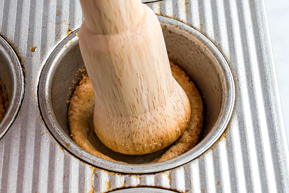 wooden dowel pressing into cookie cups