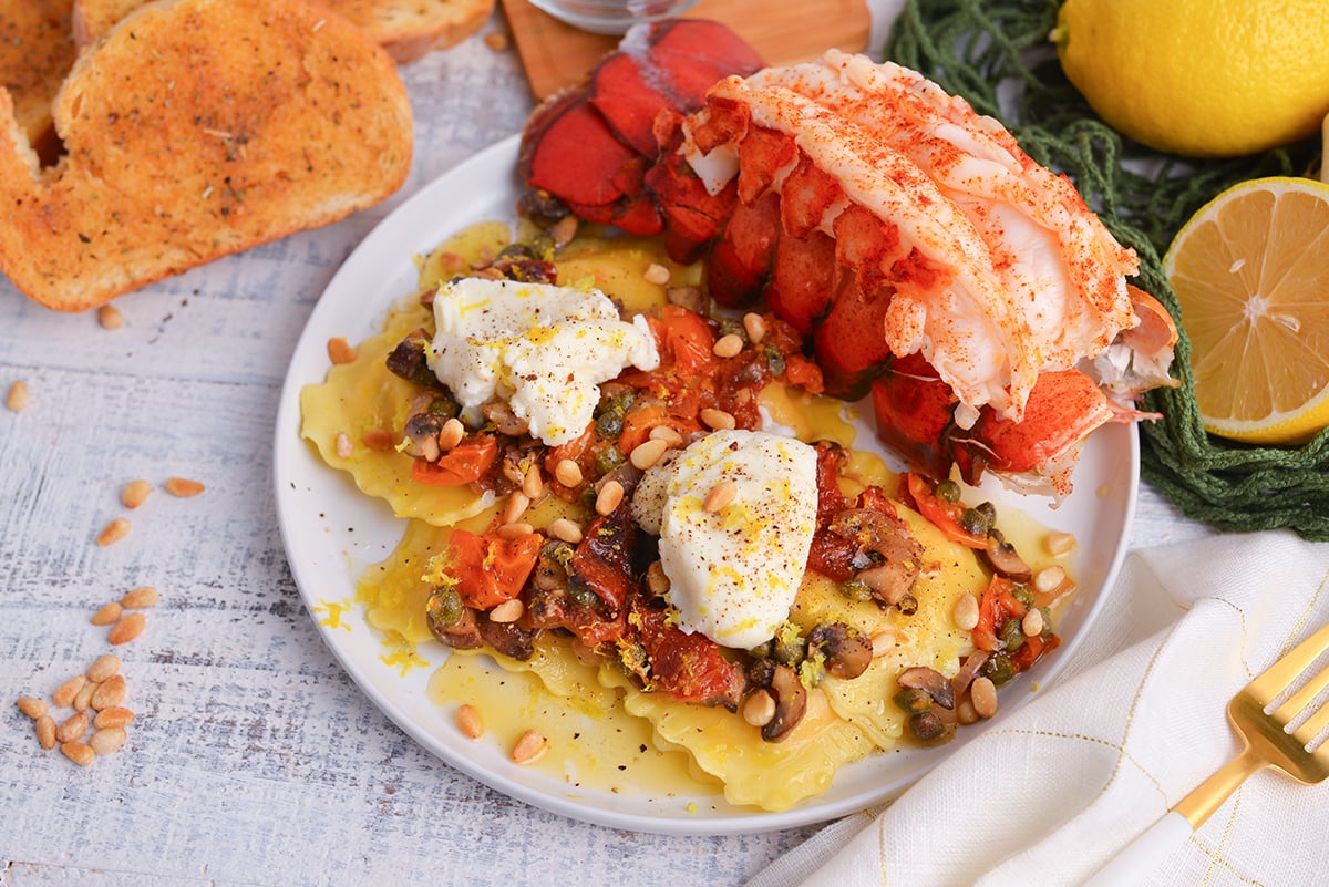 angled shot of mediterranean lobster ravioli on plate with lobster tail