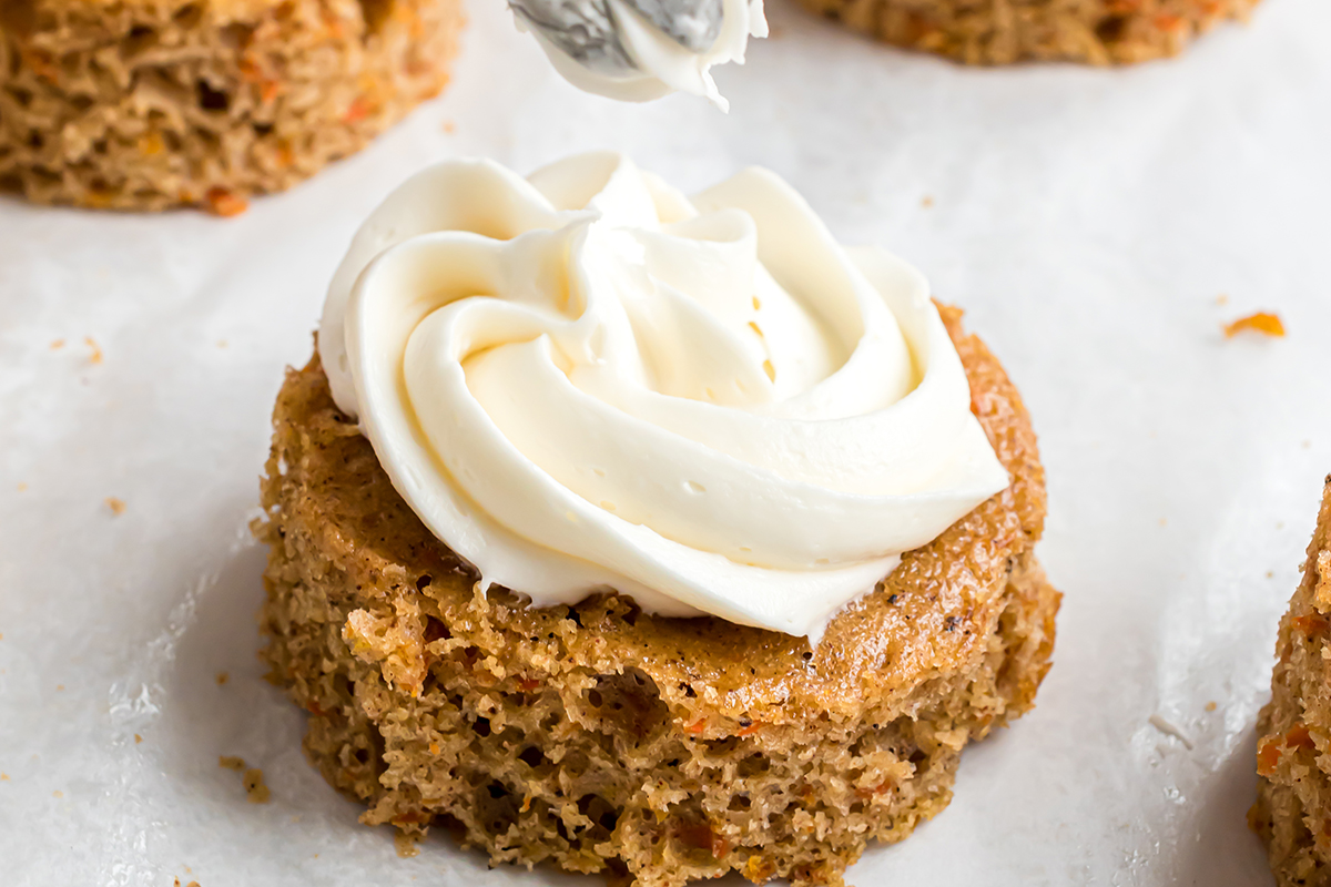 icing piped onto carrot cake circle