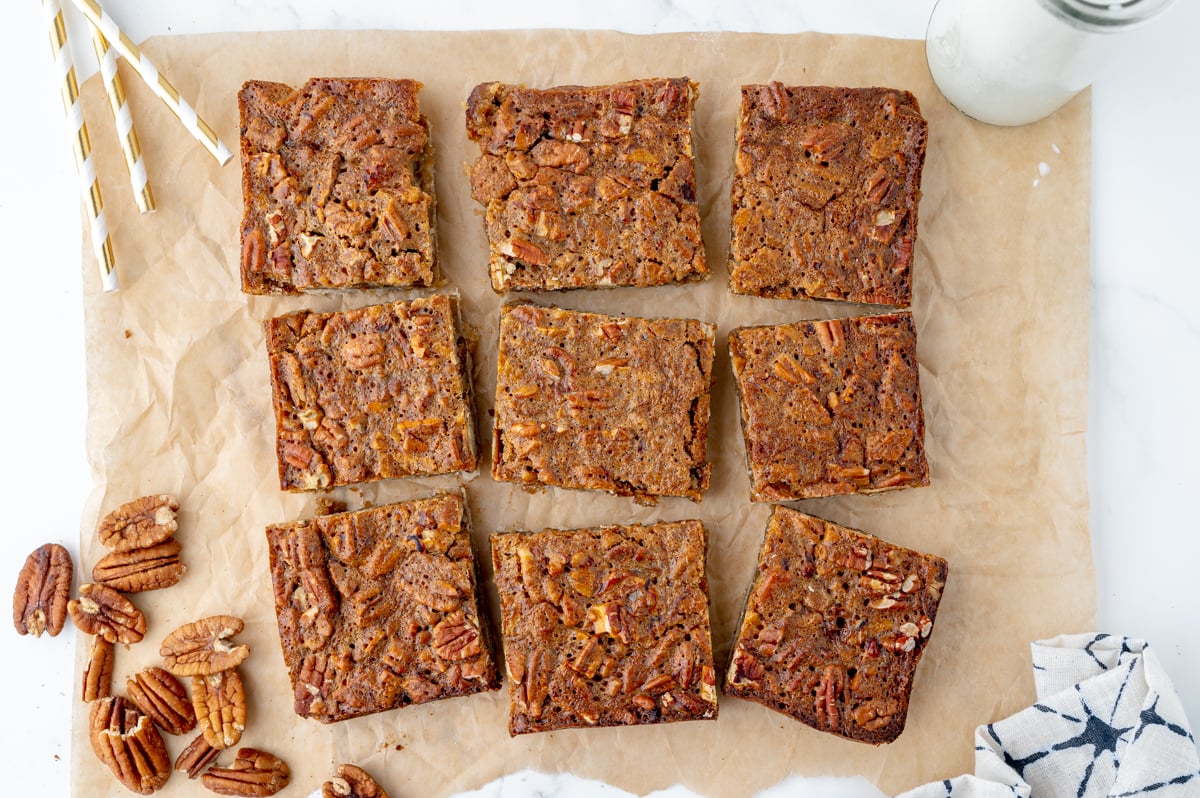 overhead shot of cut pecan pie bars on parchment paper