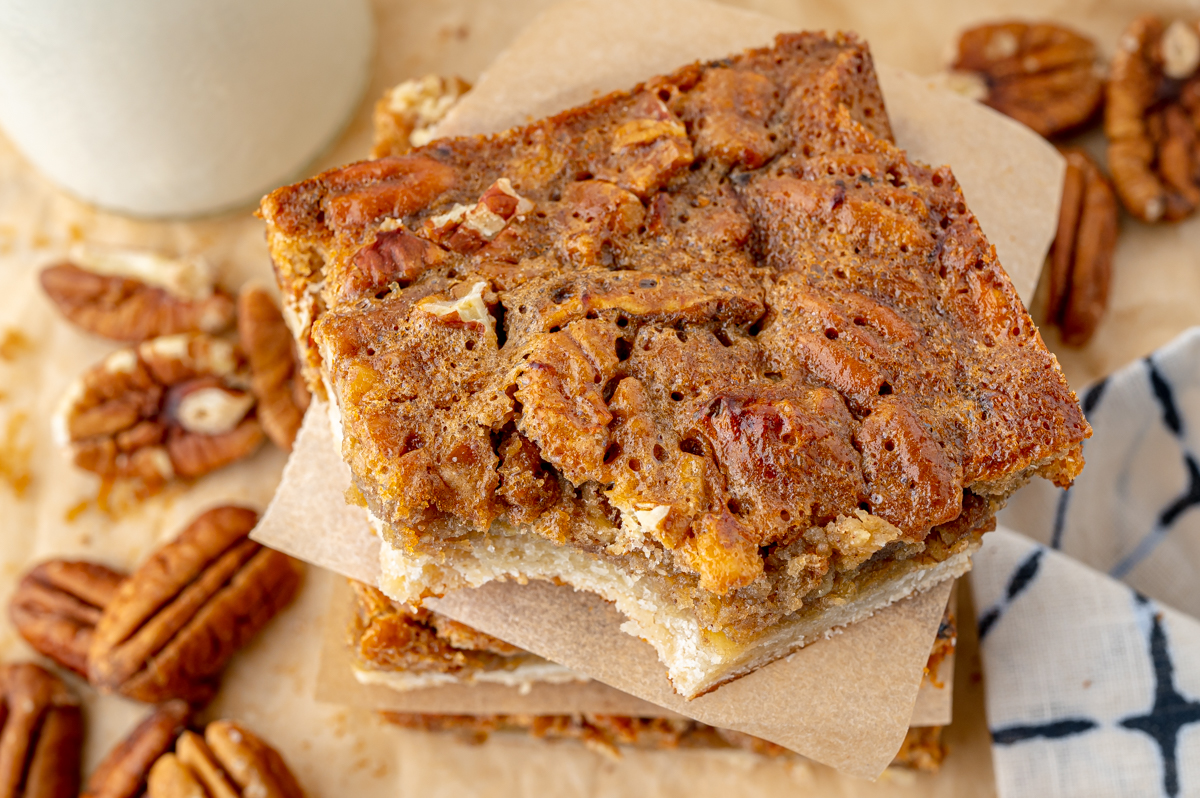 overhead shot of bite taken out of stack of pecan pie bars