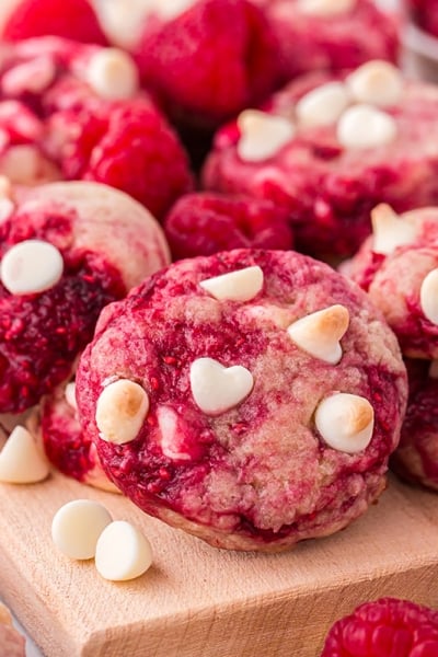 angled shot of raspberry cookies on wooden board