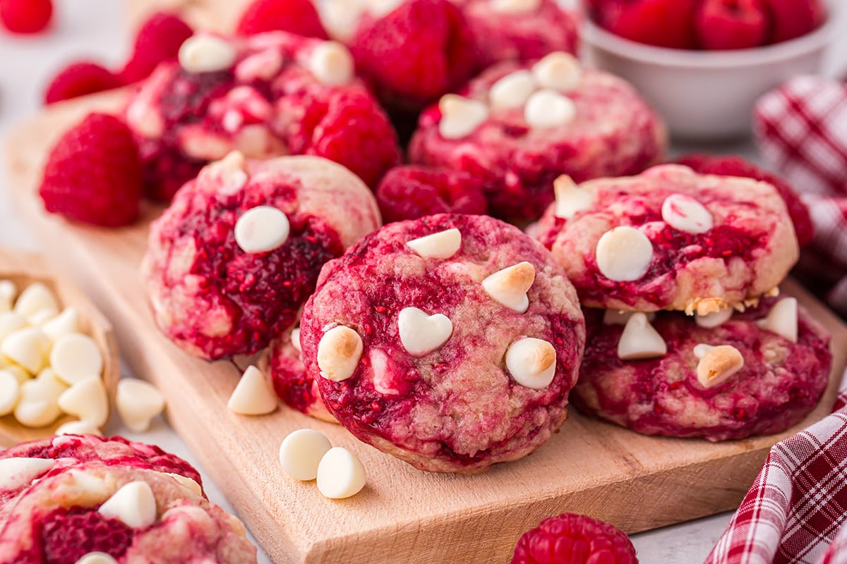 angled shot of raspberry cookies on wooden board