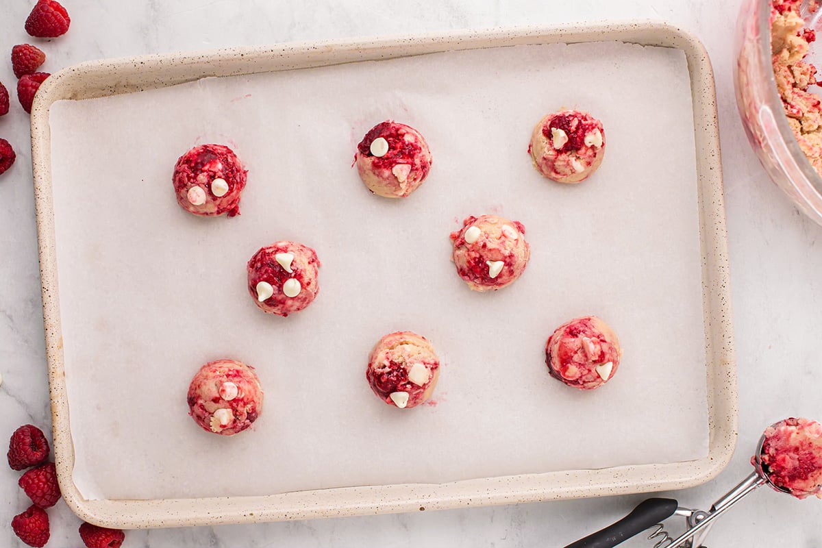 raspberry cookie dough balls on baking sheet