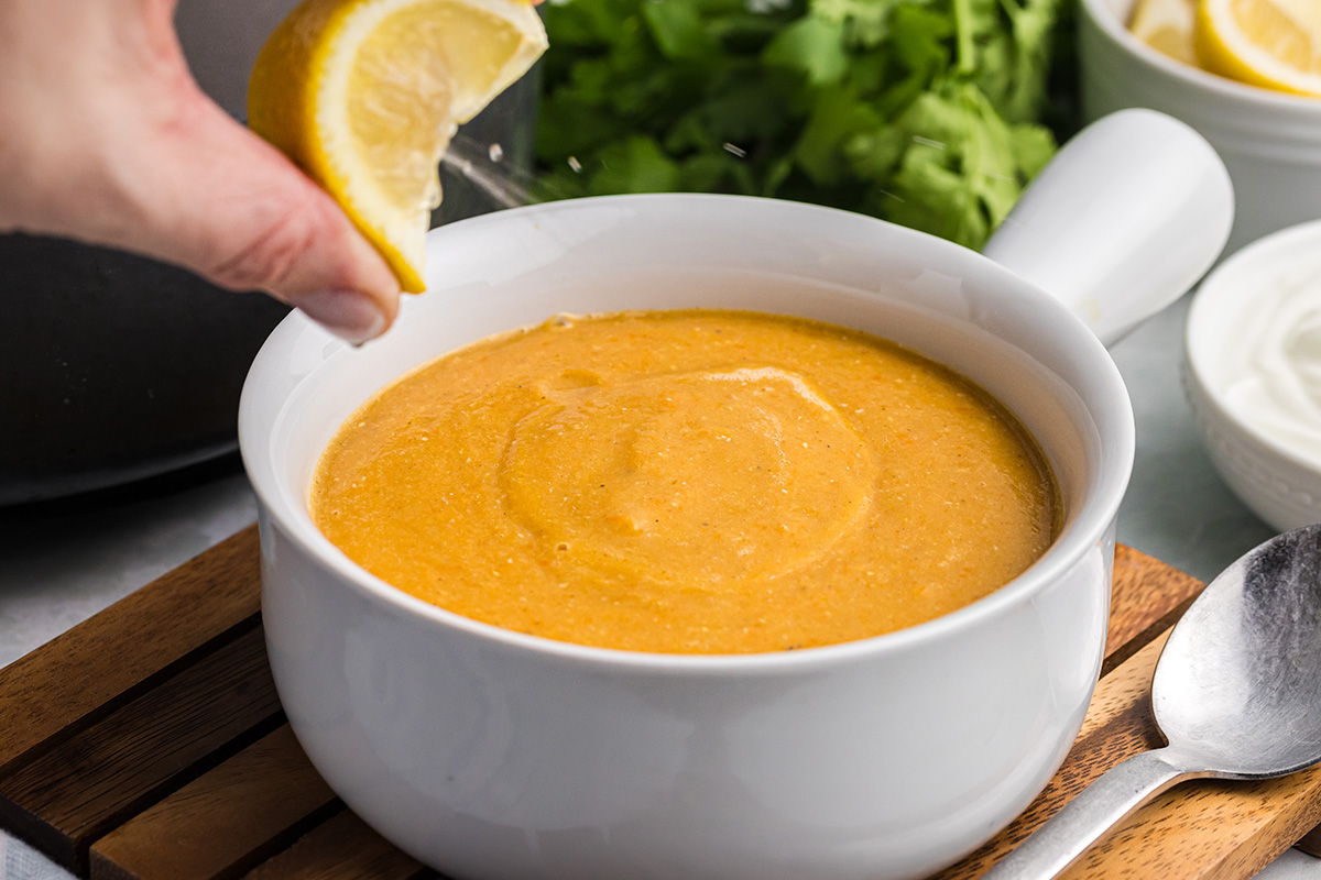 lemon wedge squeezed into bowl of soup