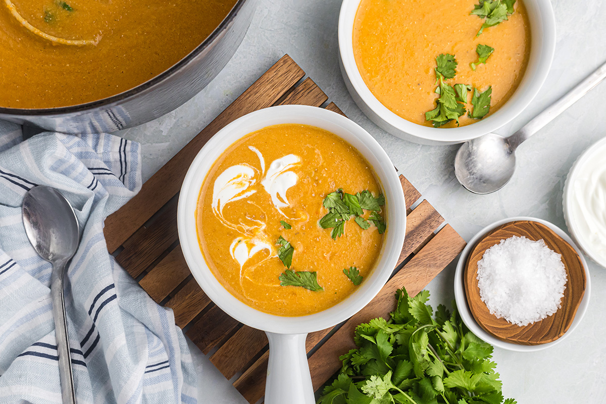 overhead shot of bowl of red lentil soup on wooden board