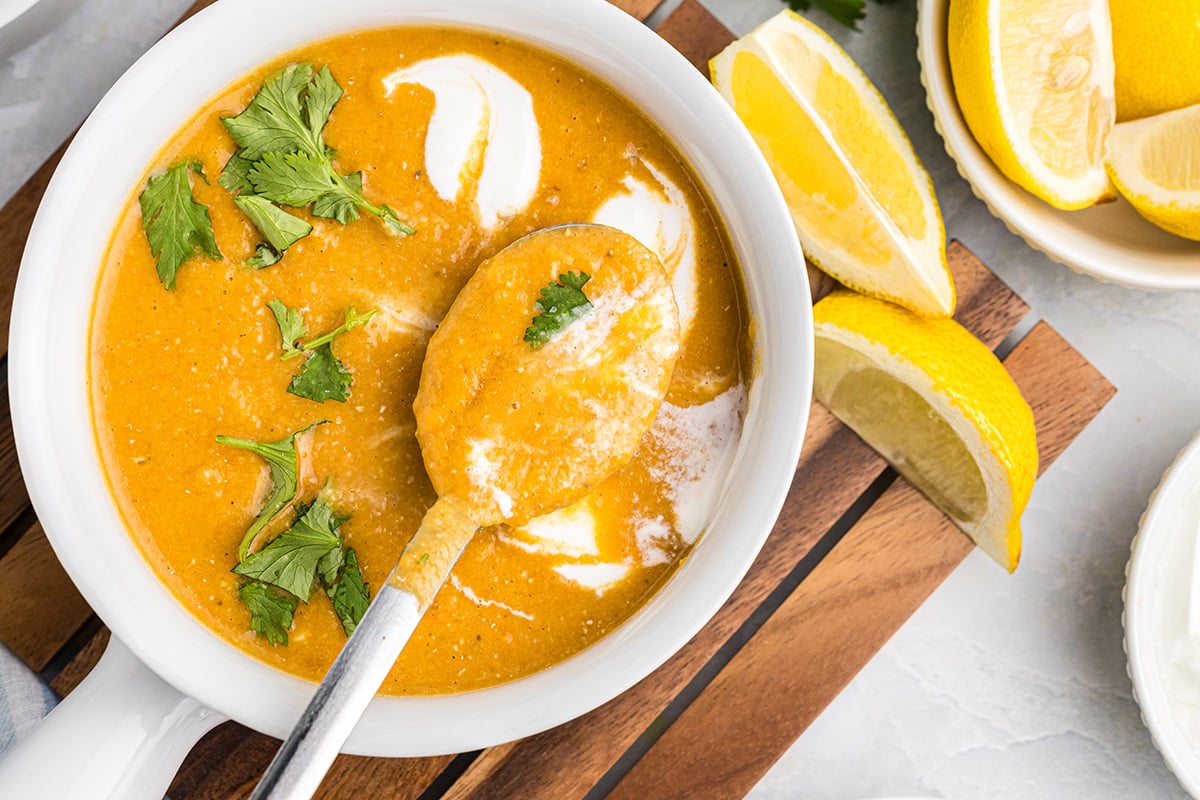 overhead shot of spoon in bowl of red lentil soup