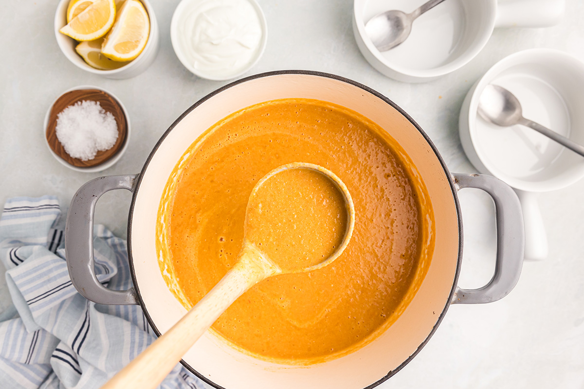 overhead shot of ladle in pot of red lentil soup