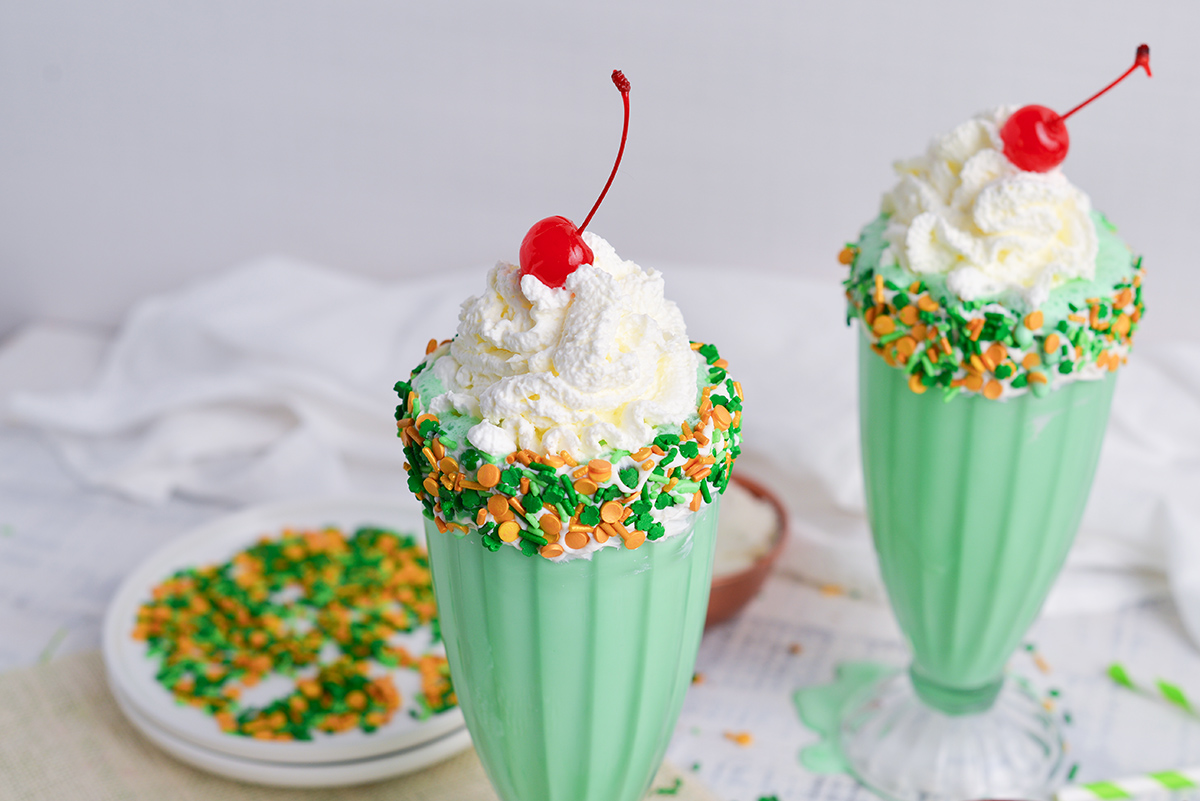 angled shot of shamrock shakes topped with whipped cream