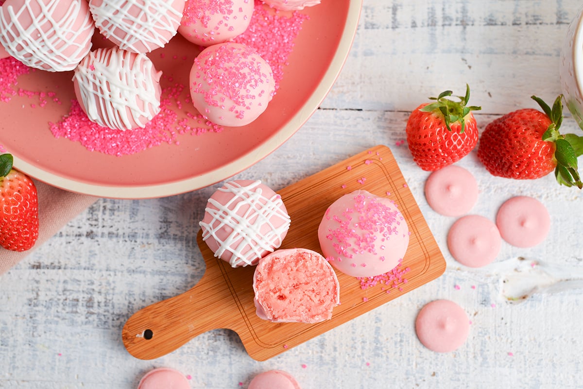 overhead shot of three strawberry cheesecake bites on mini cutting board