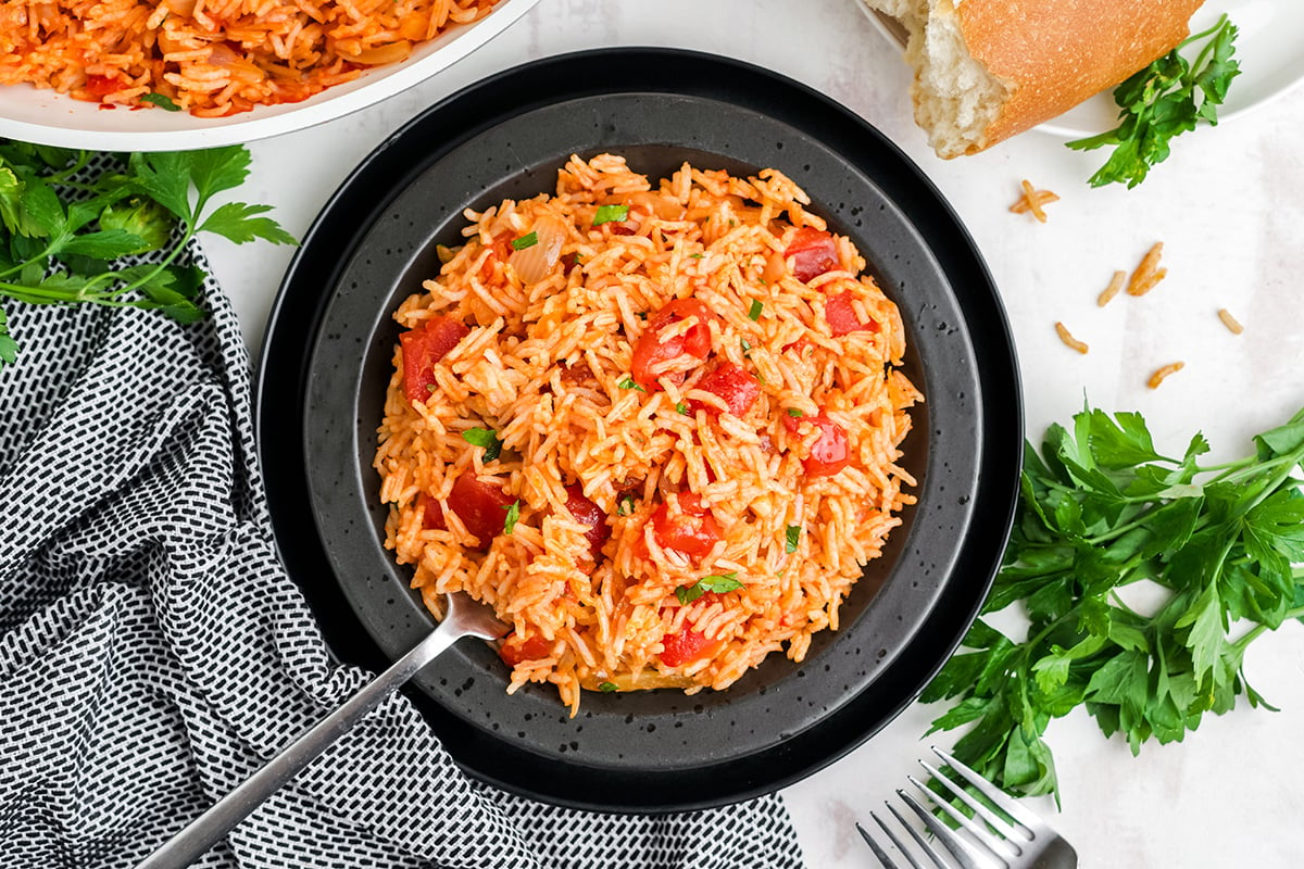 overhead shot of spoon in plate of tomato rice