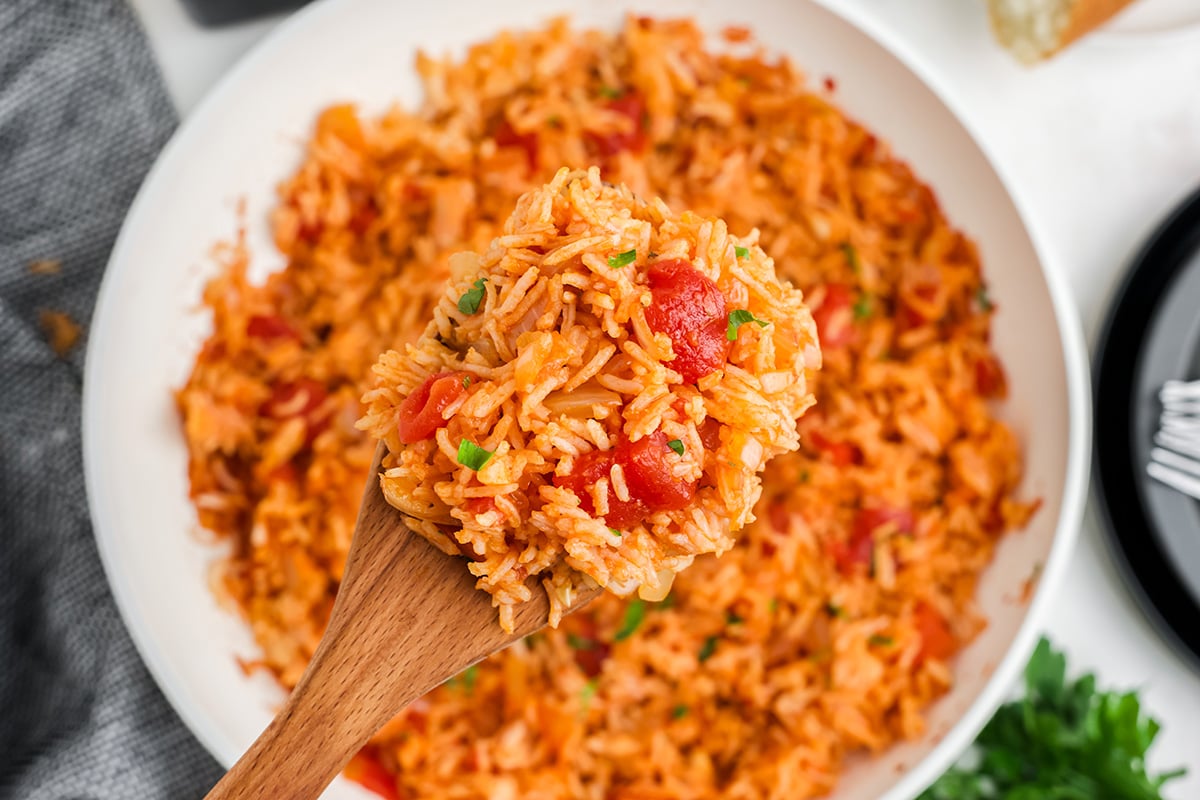 overhead shot of wooden spoon full of tomato rice