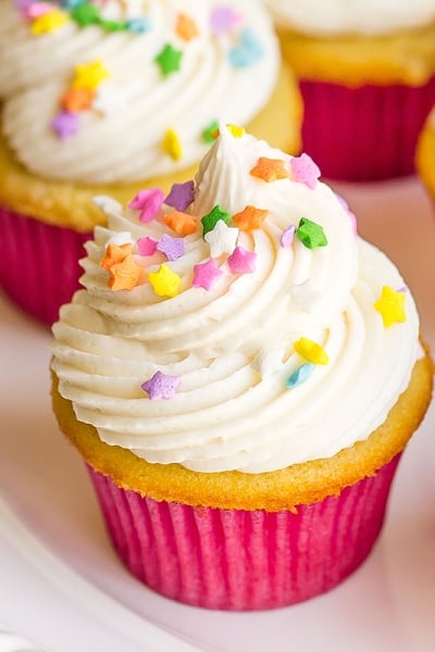 angle view of frosted vanilla cupcakes on a plate