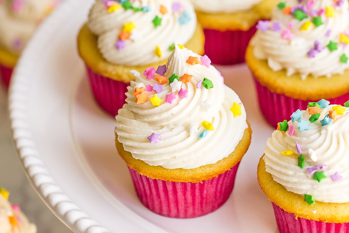 angle view of frosted vanilla cupcakes on a plate