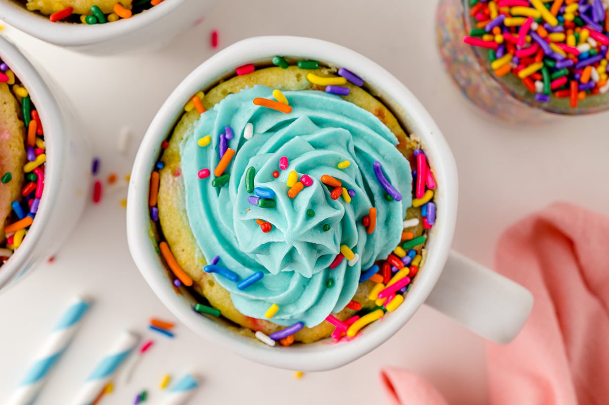 overhead of a vanilla mug cake with teal frosting