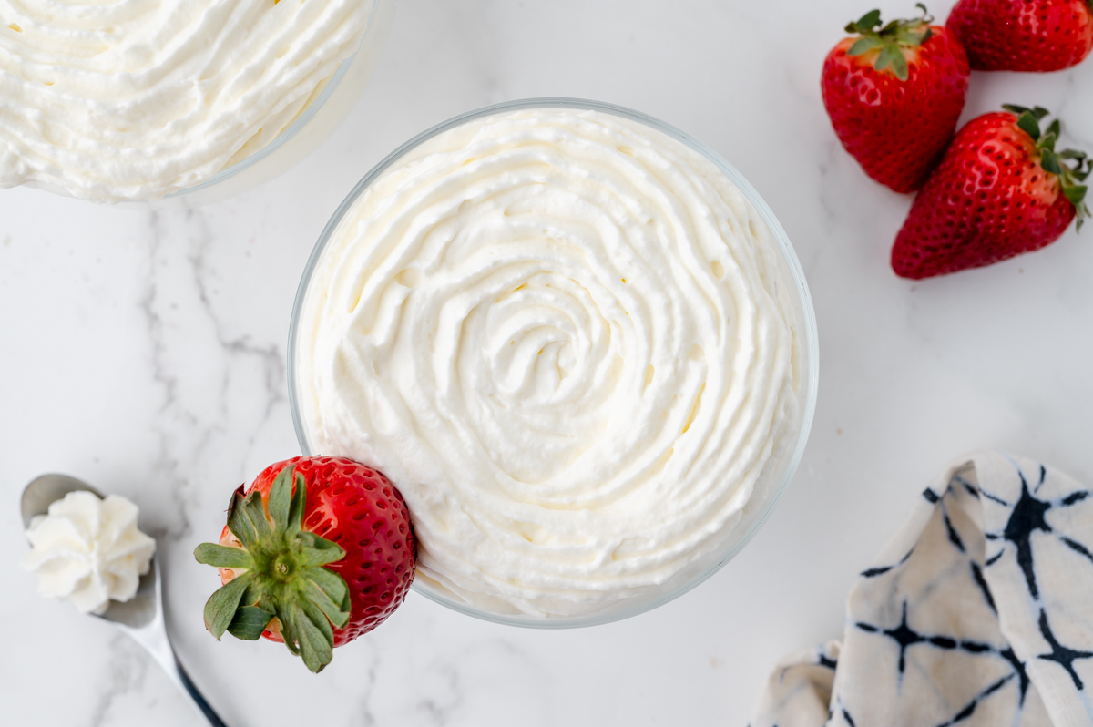 overhead shot of bowl of homemade whipped cream with strawberry