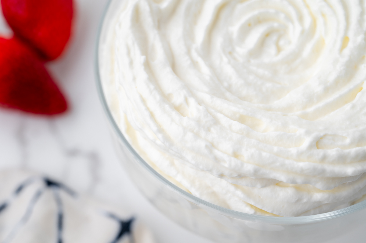 angled close up shot of half a glass of homemade whipped cream