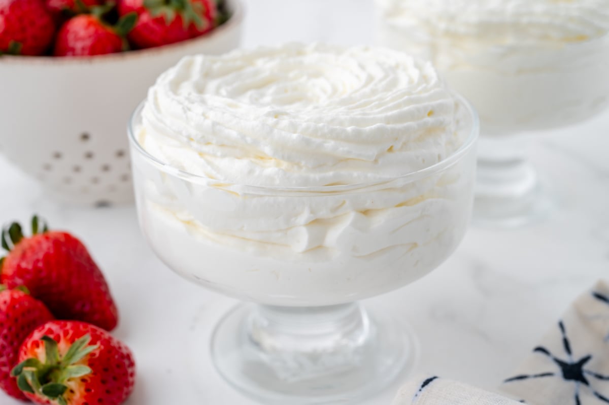 angled shot of glass of homemade whipped cream