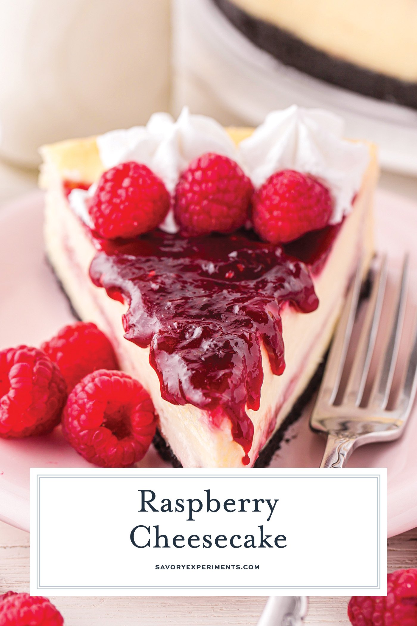 straight on shot of slice of raspberry cheesecake with text overlay for pinterest