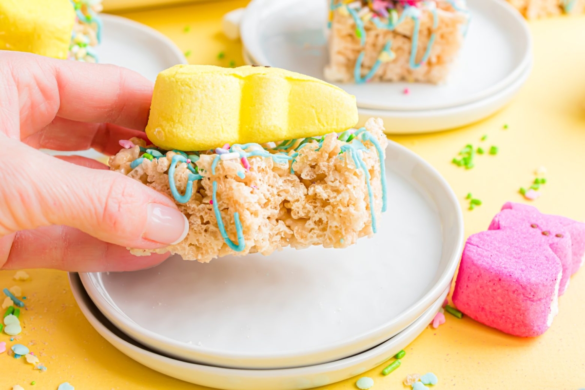 hand holding bite taken out of a rice krispie treat with peep on top