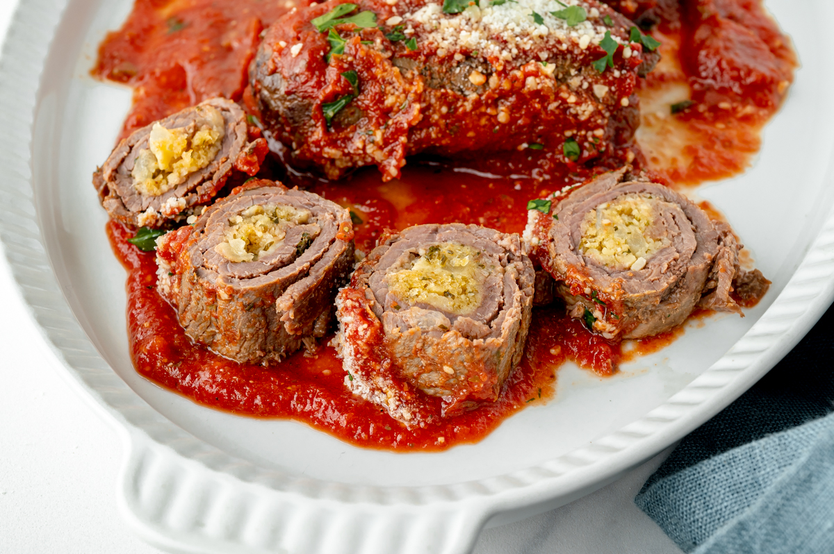 angled shot of sliced beef braciole on plate