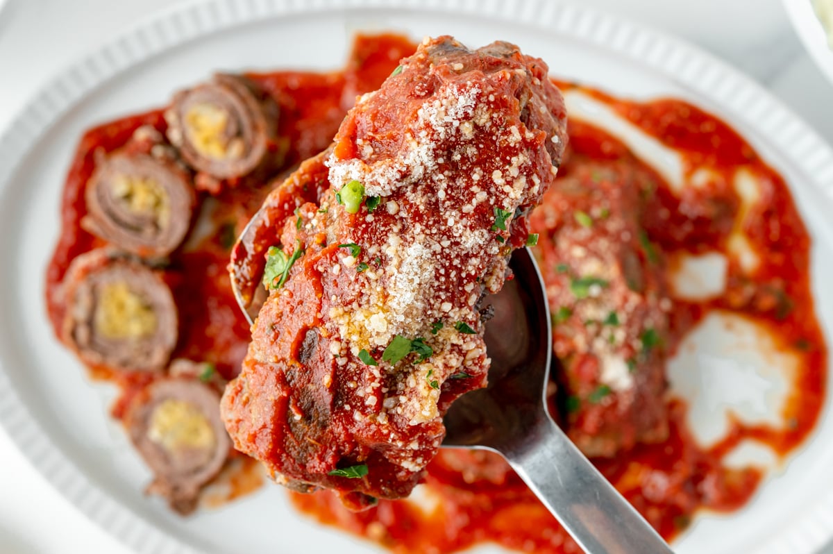 overhead shot of beef braciole on serving spoon