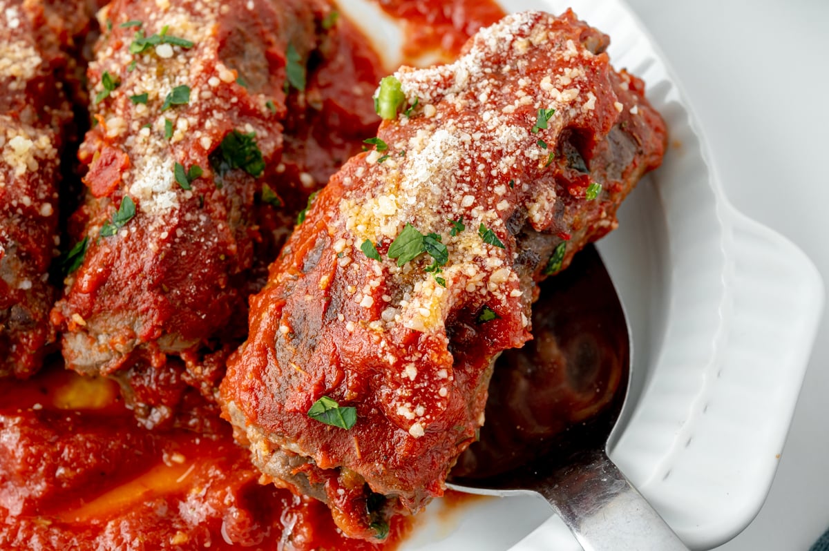 close up angled shot of beef braciole on serving spoon