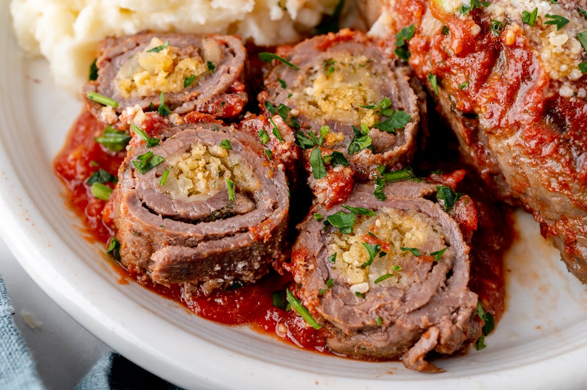 close up angled shot of sliced beef braciole on plate