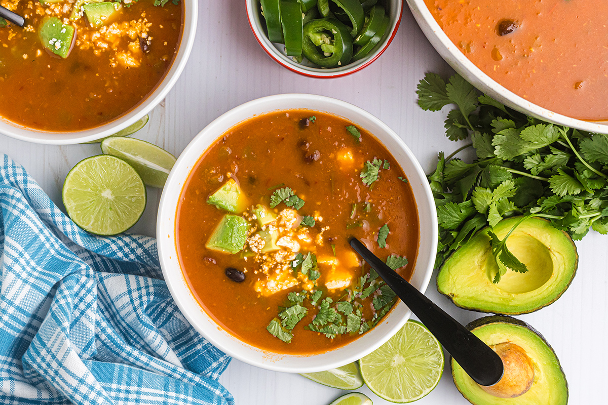 overhead shot of bowls of black bean soup with spoon