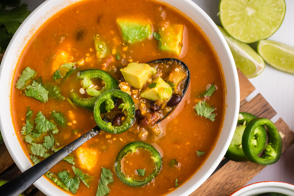 overhead shot of black spoon in bowl of black bean soup