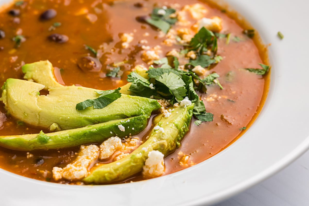 close up angled shot of black bean soup in white bowl