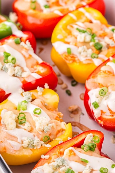 angled shot of buffalo chicken stuffed peppers in baking dish