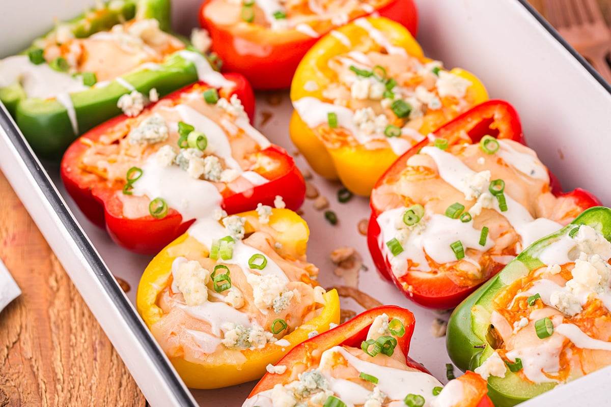 angled shot of buffalo chicken stuffed peppers in baking dish