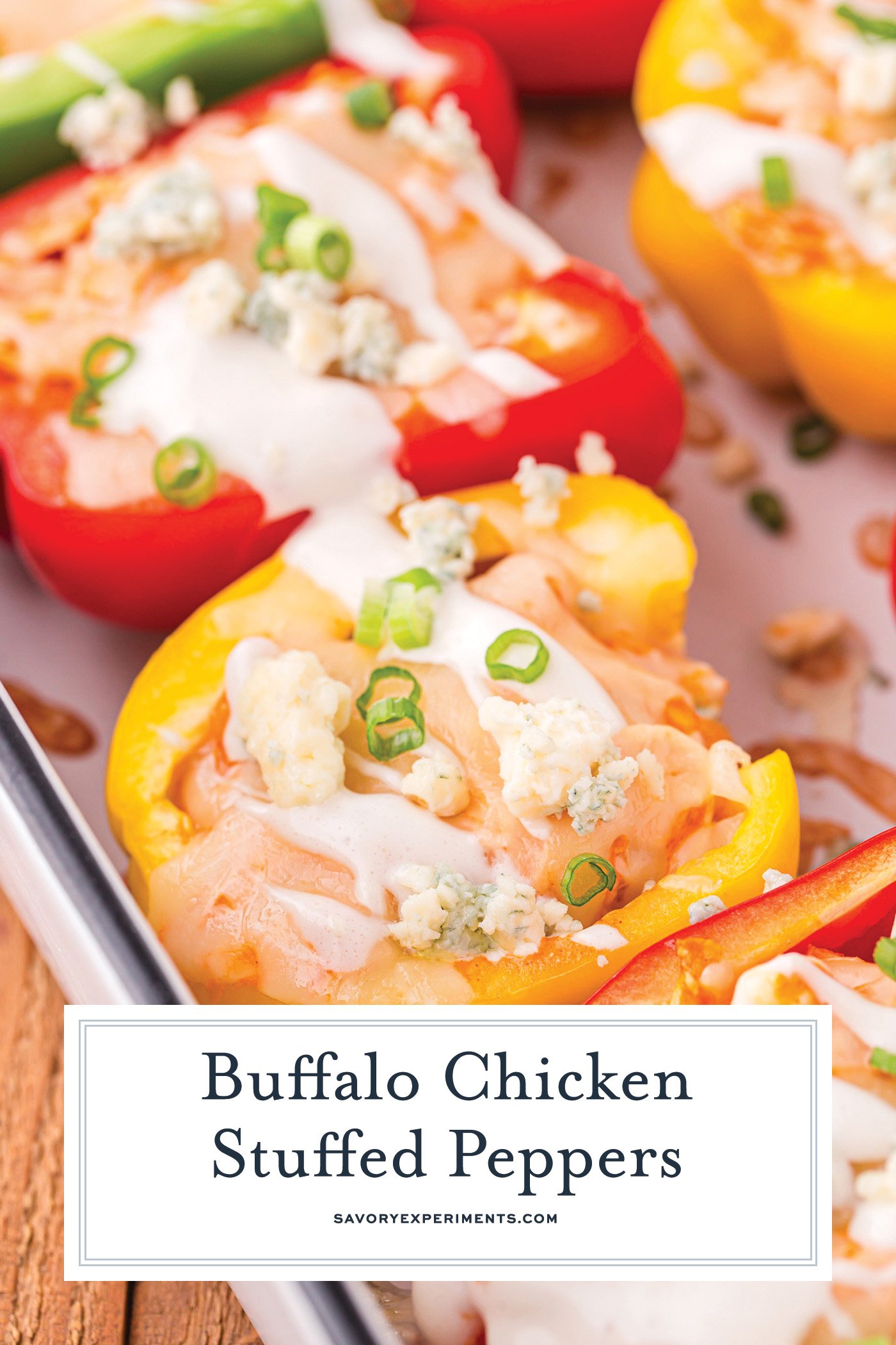 angled shot of buffalo chicken stuffed peppers in baking dish with text overlay for pinterest
