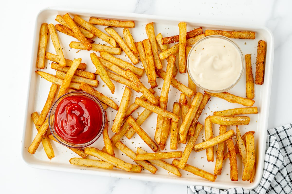 overhead shot of cajun fries on sheet pan with two sauces