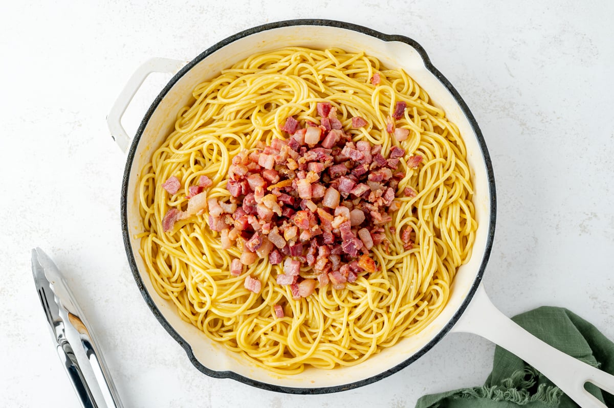 overhead shot of pancetta added to pan of pasta