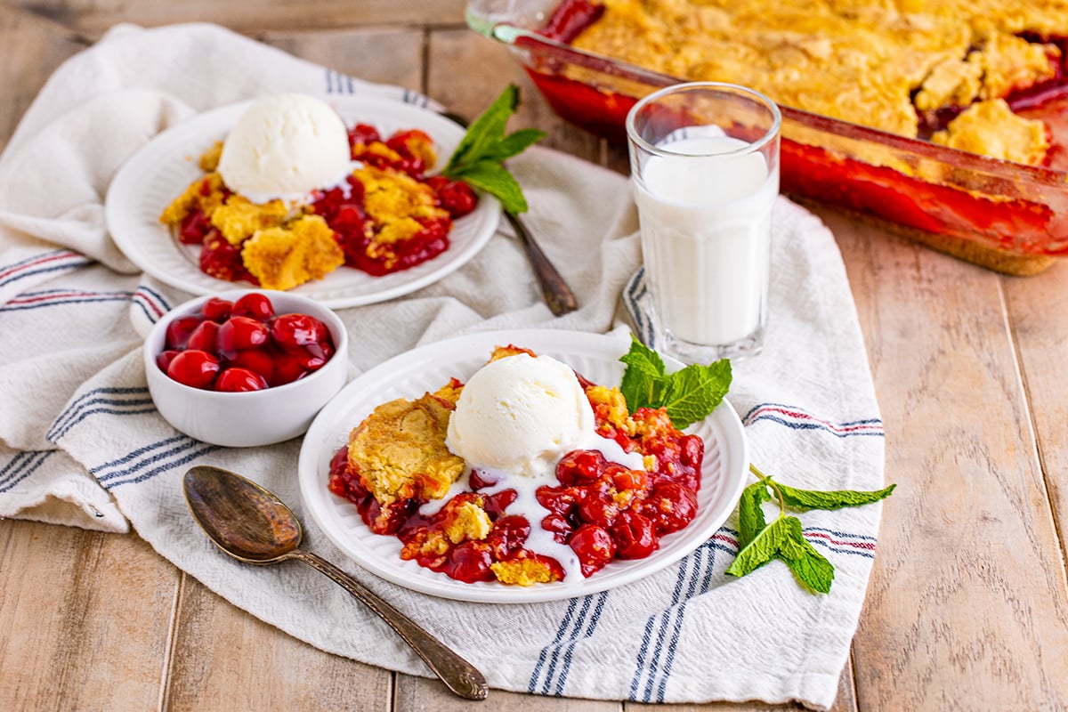 cherry dump cake topped with ice cream and garnished with mint leaves