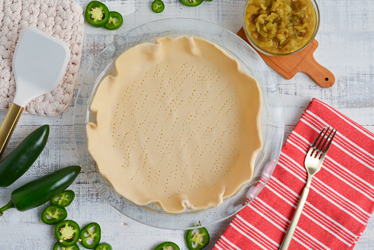 overhead shot of holes poked in raw pie crust