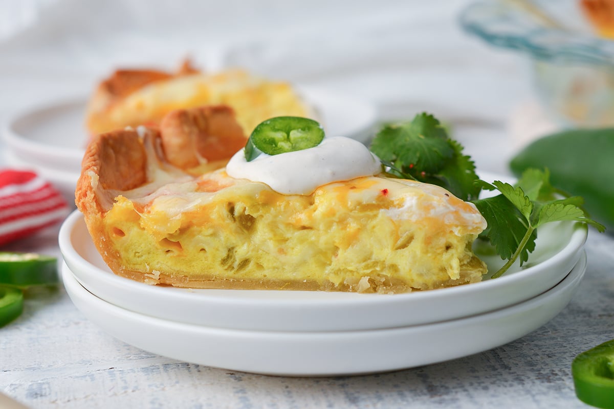 close up angled shot of slice of chile relleno quiche on plate