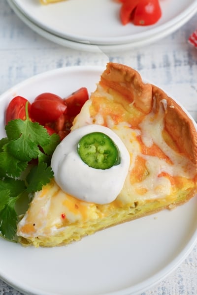 angled shot of slice of chile relleno quiche on plate