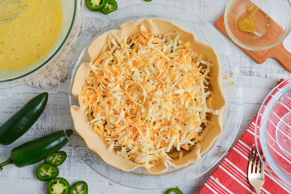 overhead shot of shredded cheese added to pie crust