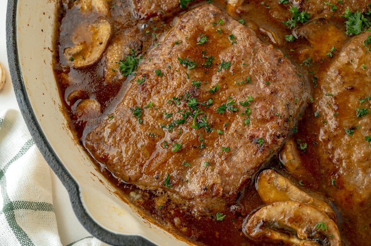 close up overhead shot of cube steak in pan