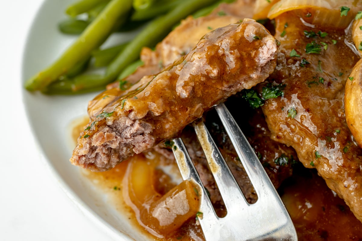 close up angled shot of bite of cube steak on fork