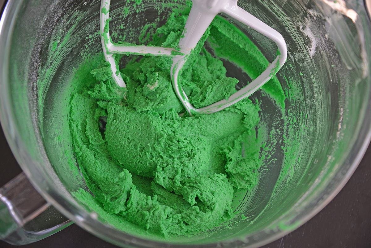 angled shot of green cookie dough in mixing bowl