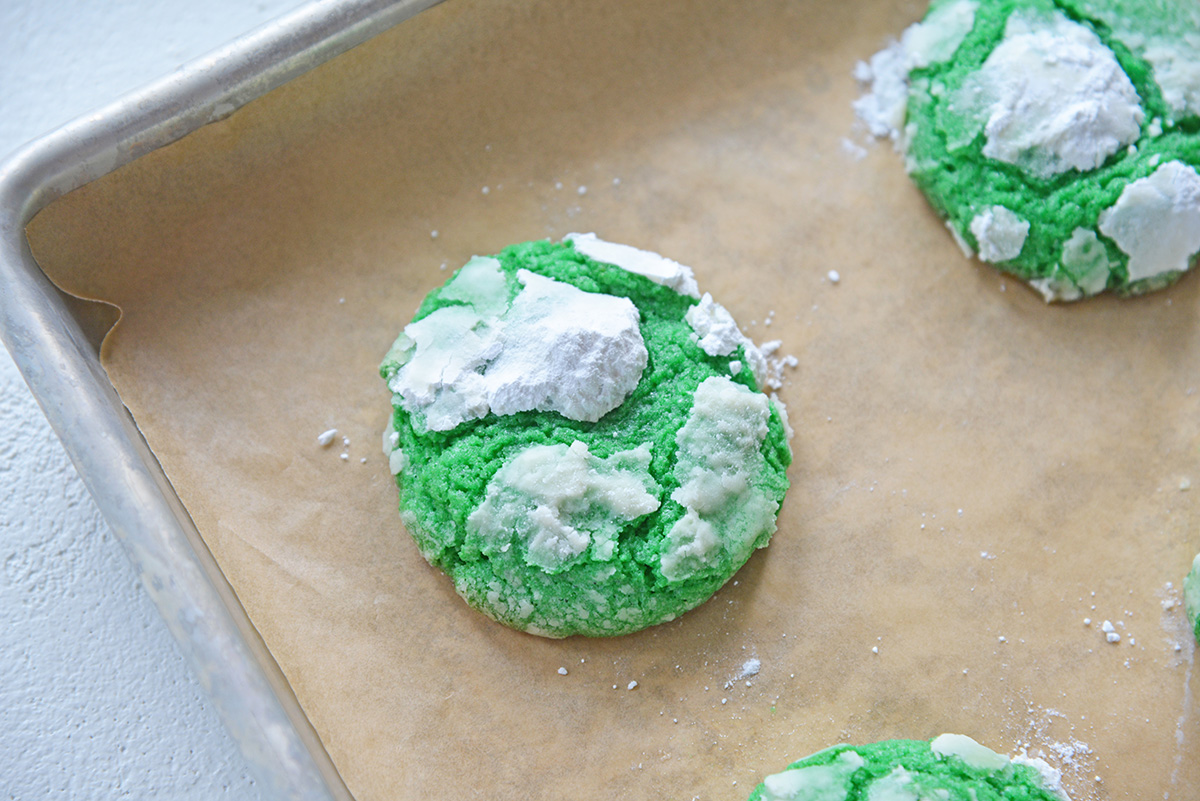 angled shot of green mint crinkle cookies on parchment paper