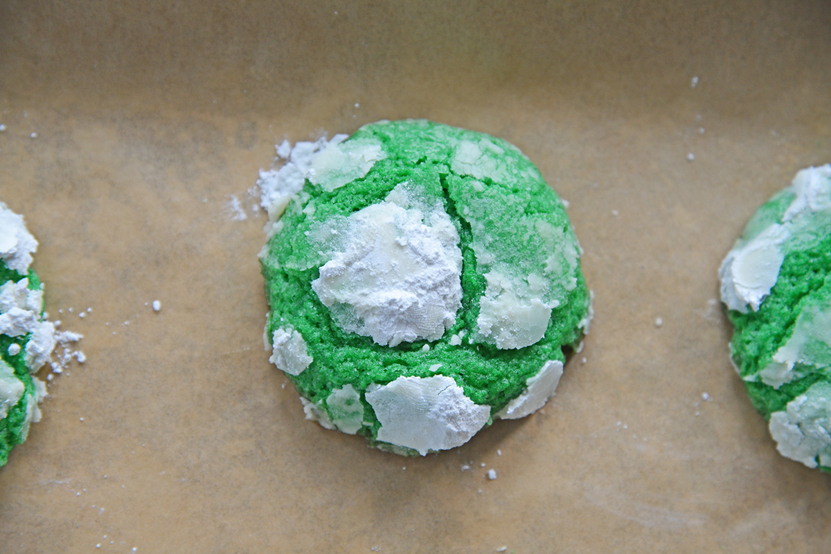 close up overhead shot of green mint crinkle cookie on parchment paper