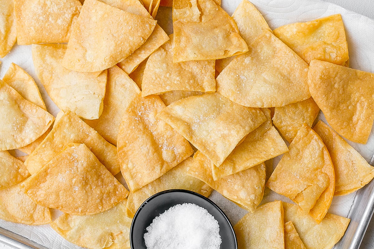 overhead shot of tray of tortilla chips with bowl of sea salt