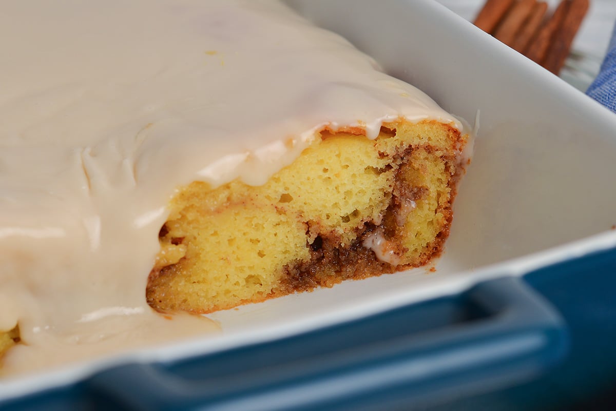 close up angled shot of slice of honey bun cake taken out of pan