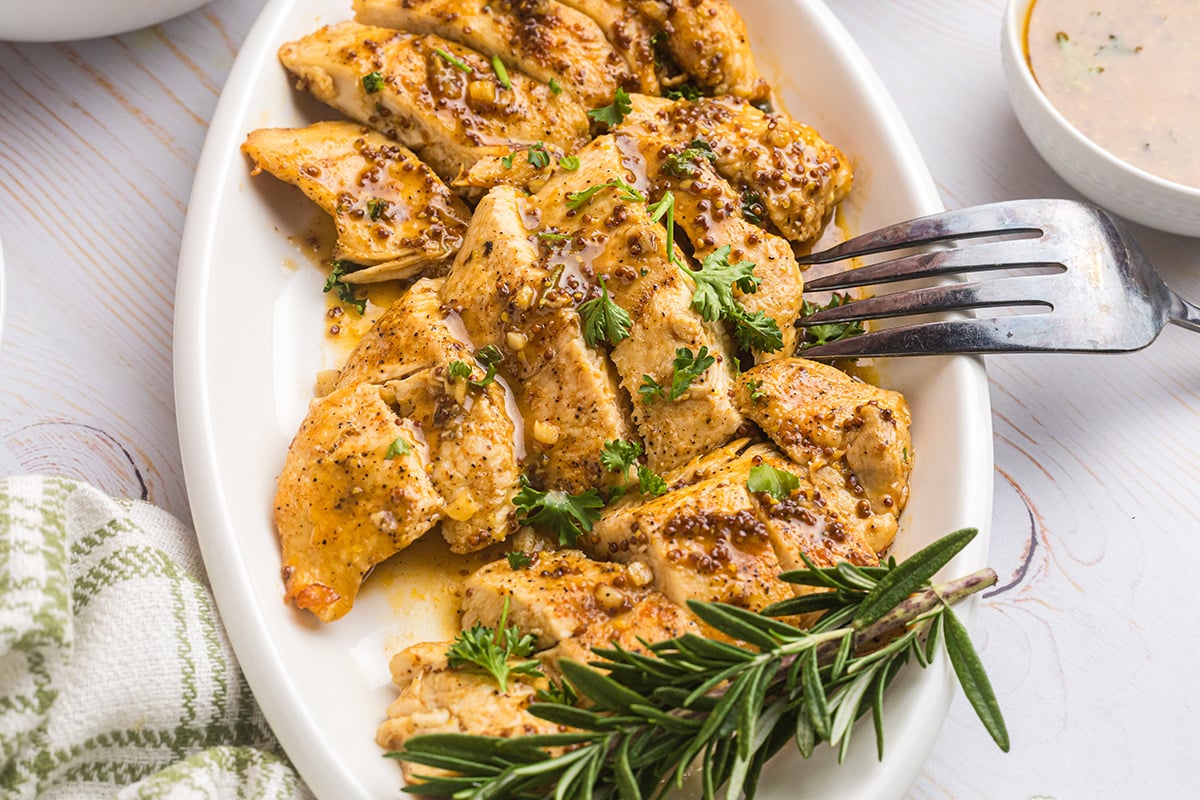 angled shot of sliced honey mustard chicken on platter